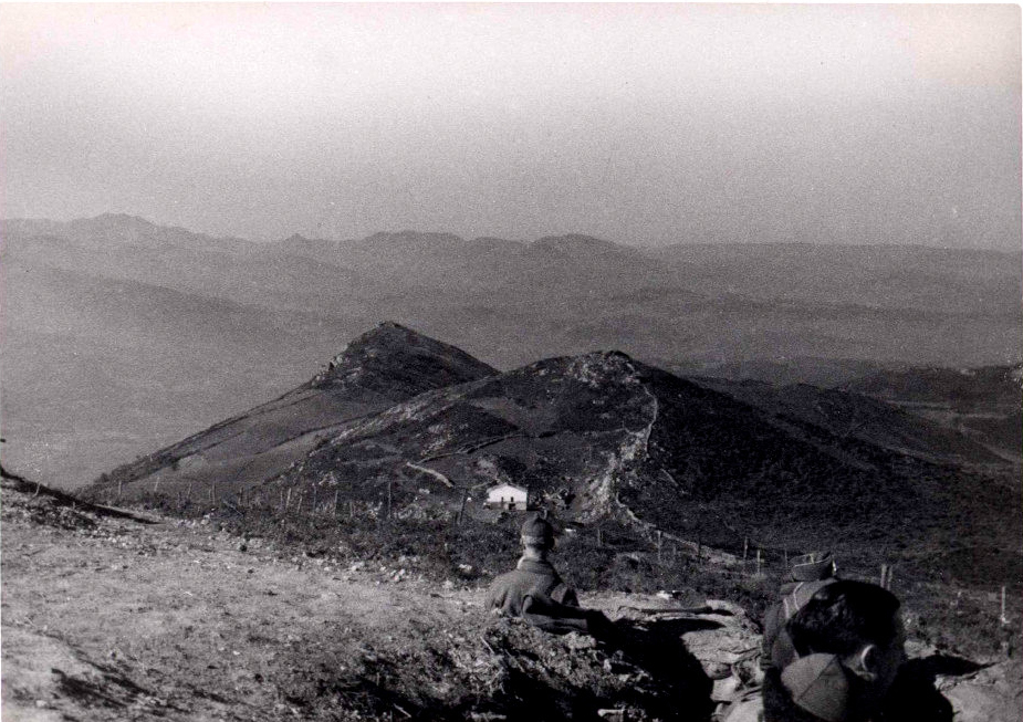 foto de posiciones en el Monte Naranco. Se ven fotos de soldados en una trinchera y al fondo montañas.